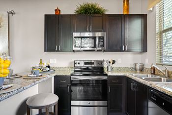 a kitchen with black appliances and granite counter tops and black cabinets